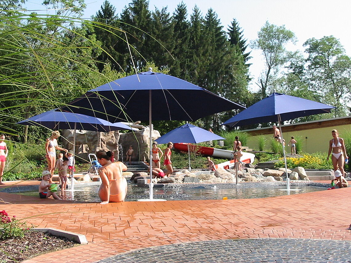 Das Kinderbecken im H2Ö - das Strandbad mit großen, blauen Sonnenschirmen ist zu sehen.