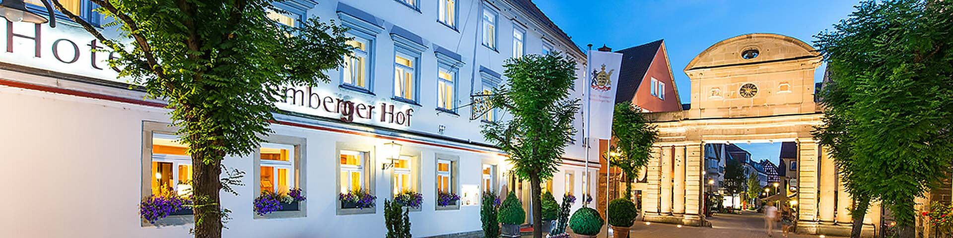 Ein Hotel in Öhringen ist zu sehen, daneben das beleuchtete "Obere Tor" aus Sandstein.