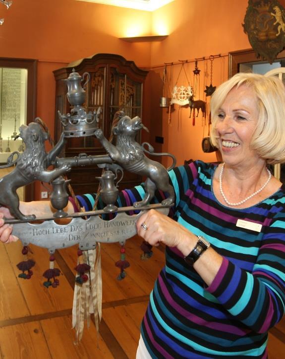 Eine Führerin des Weygang-Museums zeigt ein Stück aus der Zinnsammlung.