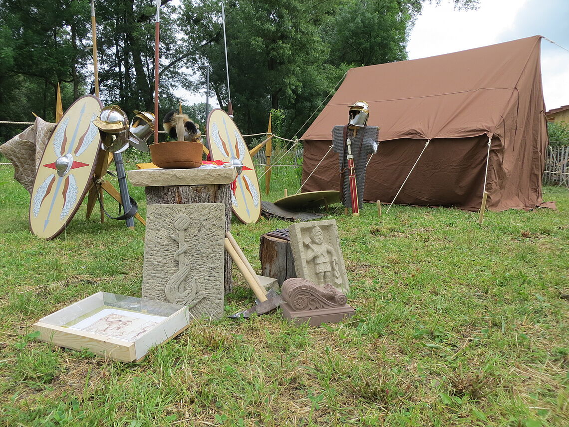 Ein römisches Feldlager mit Zelt, Militärausstattung und Handwerkskunst ist zu sehen.