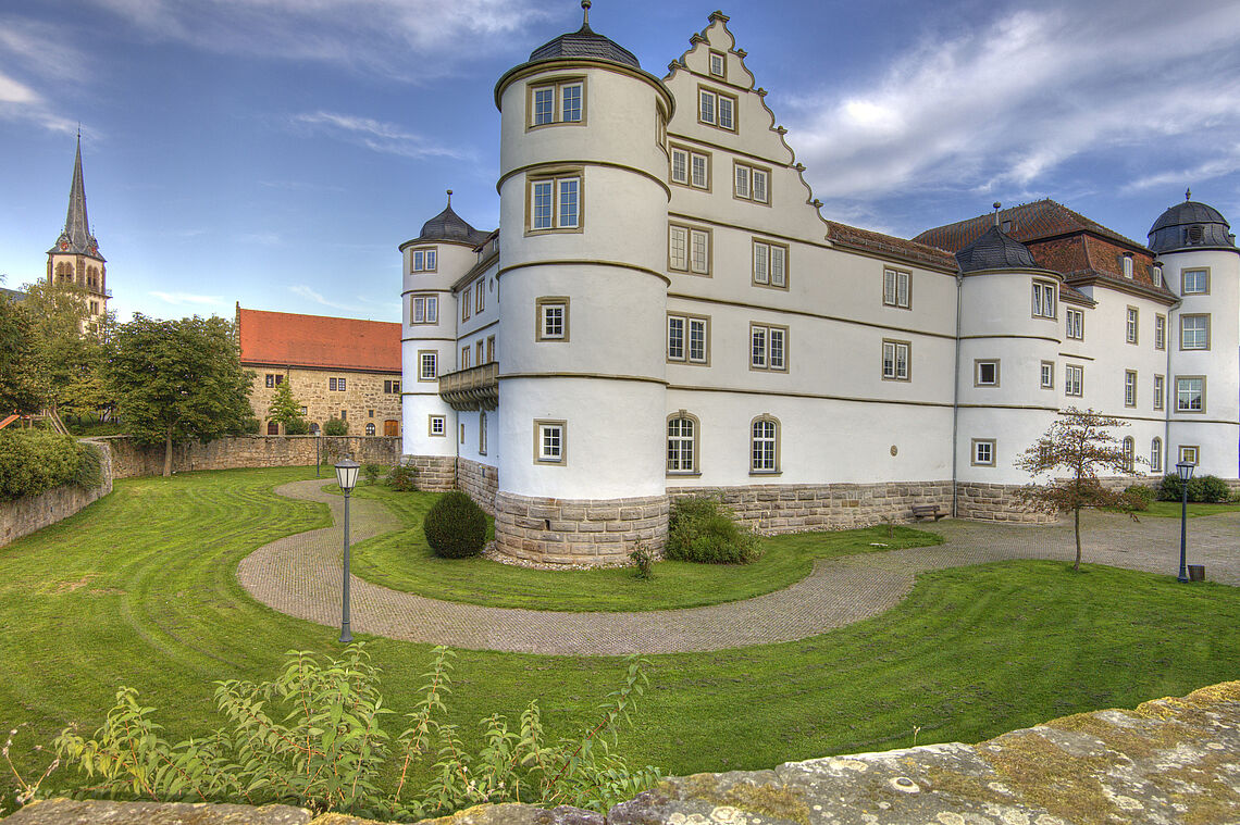 Das Schloss in Pfedelbach ist zu sehen. Im Vordergrund sieht man den bepflanzten Schlossgraben.