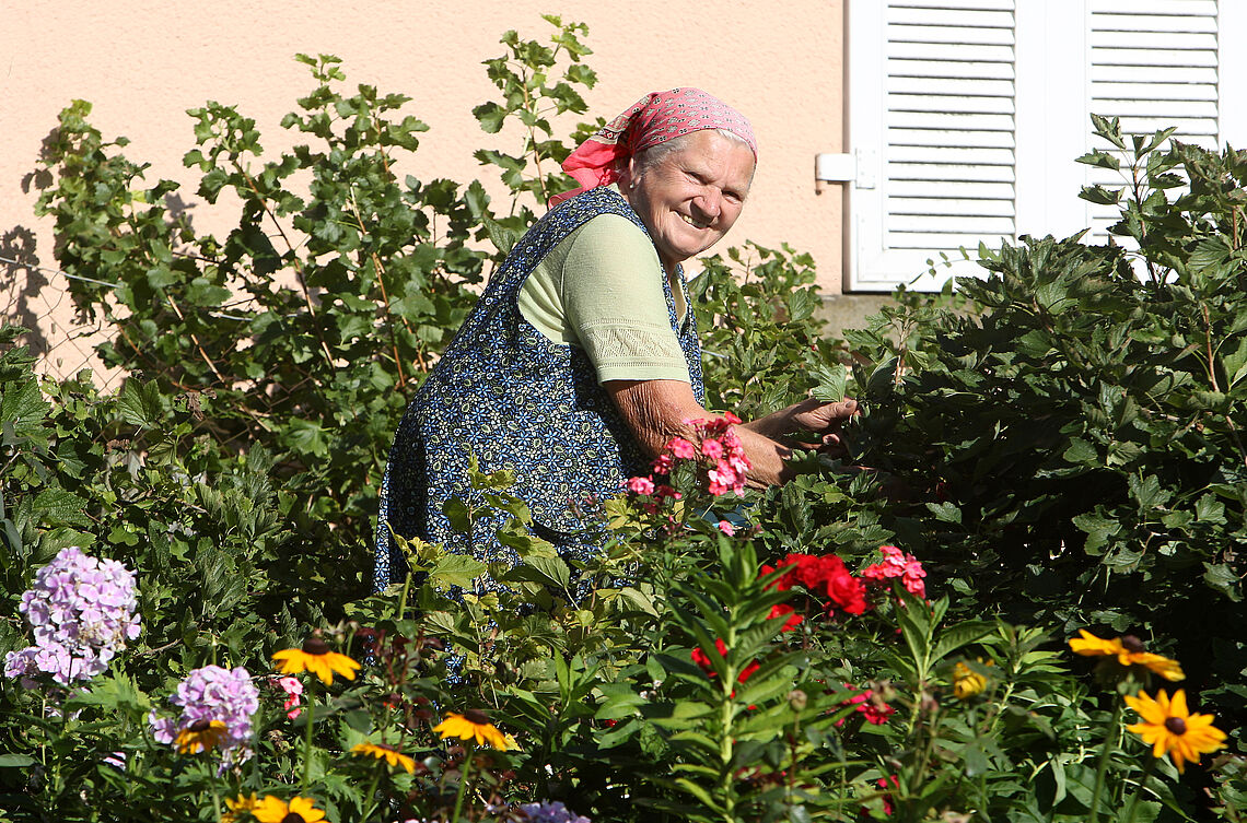 Mundartführungen - Ältere Dame im Blumengarten