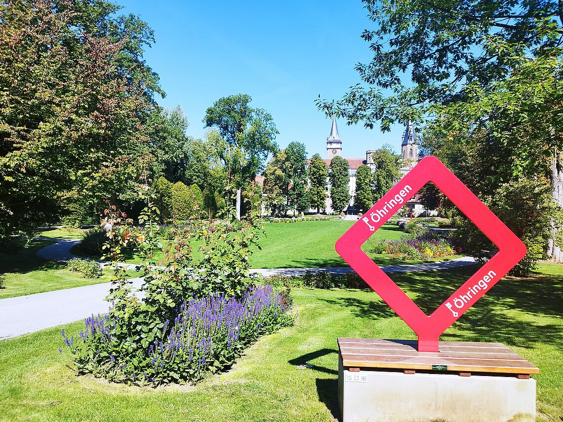 ein roter Selfie Point im Hofgarten mit Blick auf das Schloss und Schlosstreppe